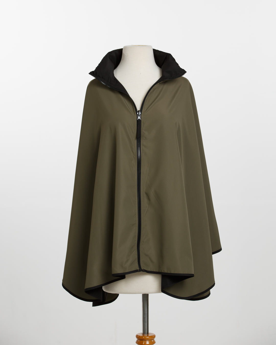 Green cape on a mannequin against a white background