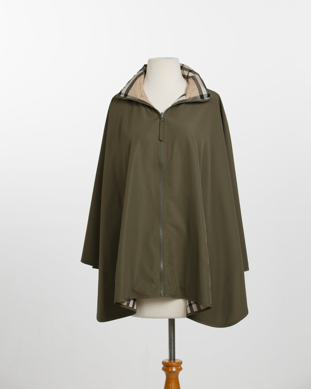 Green raincoat with checkered lining on a mannequin against a white background